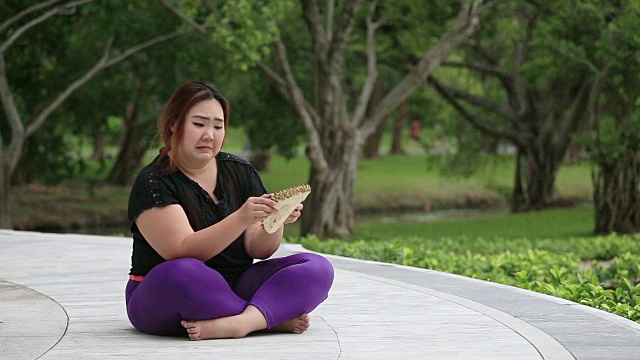 漂亮的胖女人闻到榴莲的味道，就把它放下。