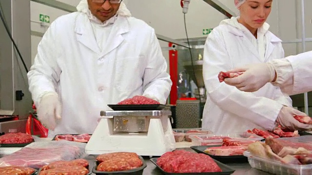 屠夫在肉品工厂包装和检查肉类的重量