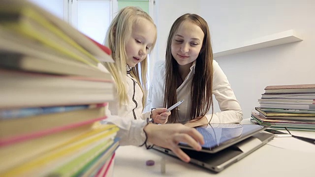 女学生和一位年轻老师一起上计算机课。