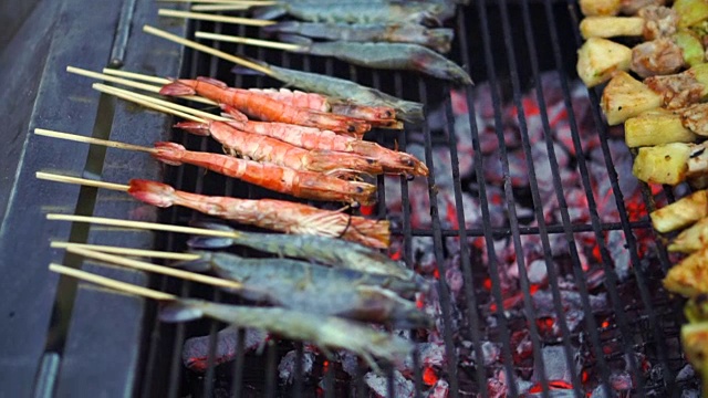 猪肉、蔬菜、虾和虾串在木炭烤架上