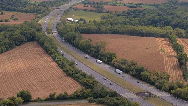 AERIAL:穿过农田，田野和森林的国家州际公路