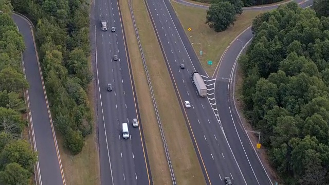 空中镜头:早上在州际公路上飞驰的半卡车和私家车