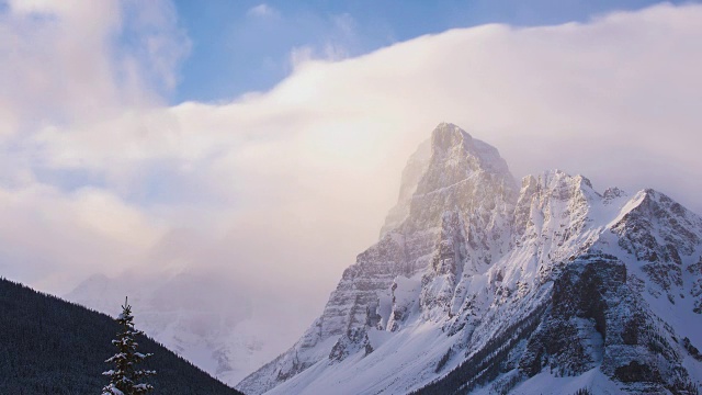 日出时，雪山山顶上的流云