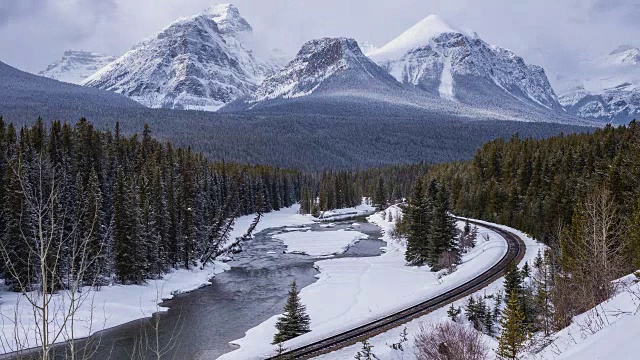 火车轨道的时间流逝旁边的河流在下雪的山区