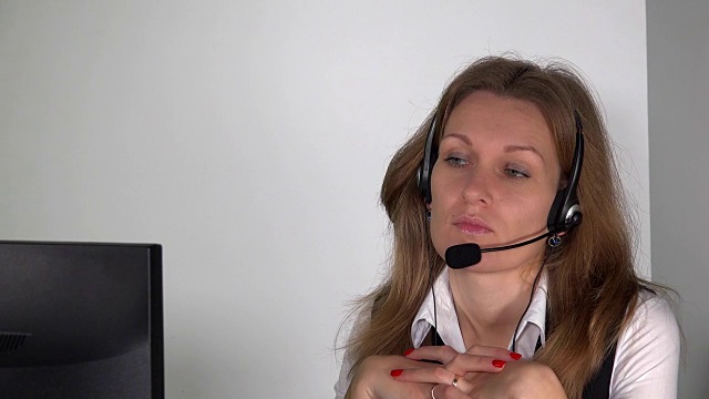 自信的女客服顾问戴着耳机坐在电脑前