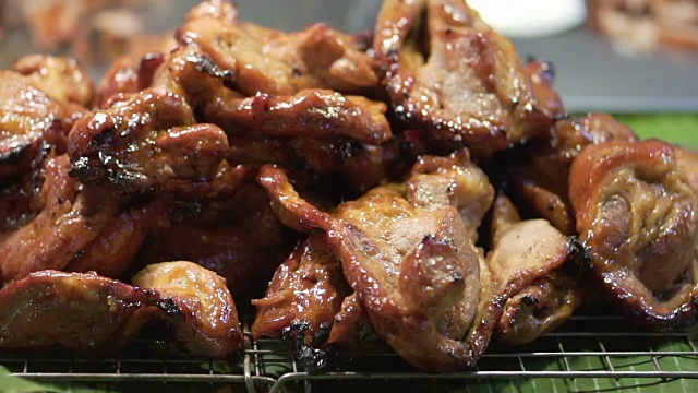 泰国当地食品博览会上，一堆红色的香蕉叶烤猪肉