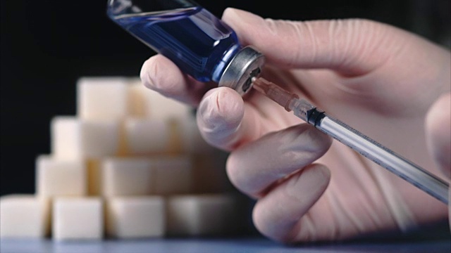 糖尿病的概念。方糖和胰岛素安瓿注射器