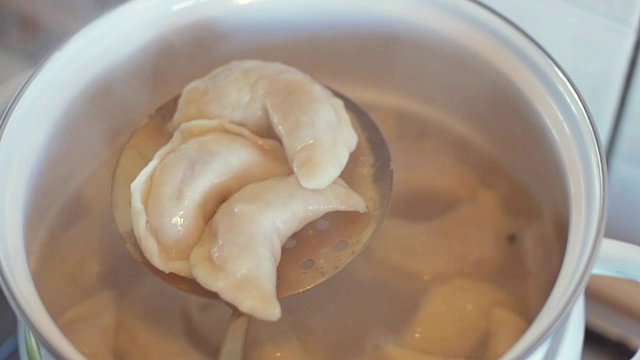 饺子是放在盛有沸水的炖锅里煮的。用勺子把热饺子从锅里捞出来