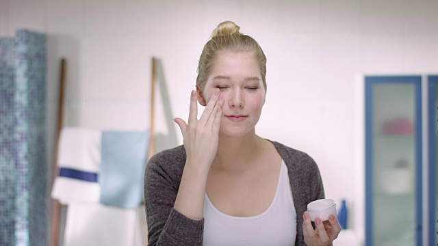詳情圖-年輕的白人婦女在她的皮膚上涂面霜