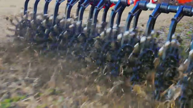 详情图-斯坦尼康跟踪镜头:一个特写的一部分农业机器是一个旋转的中耕机。处理地面以清除杂草和防止土壤干燥