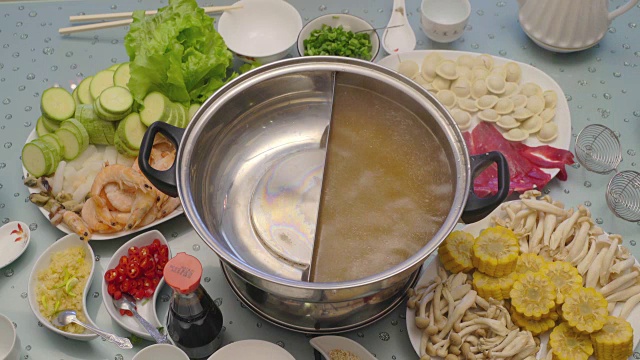 亚洲美食的概念。没有经验的厨师把汤倒在特制的锅里