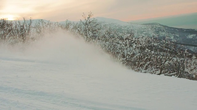 滑雪板斜线转弯在日落前的剪影橙色的云高速行动冬季高山运动