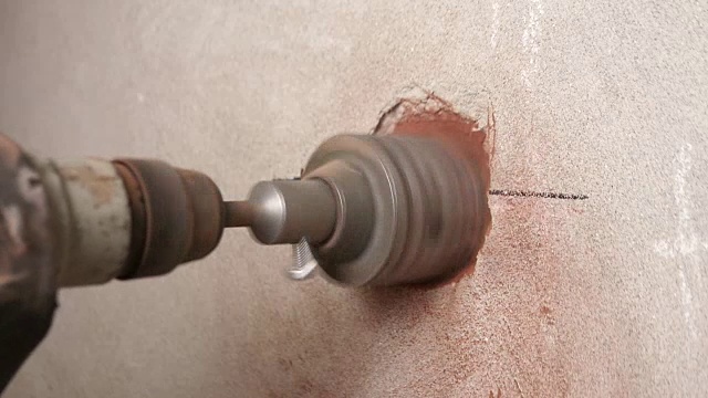 新公寓砖墙上的钻石钻孔机。特写镜头