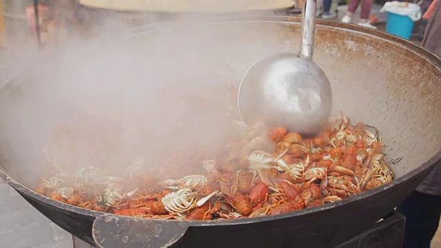 龙虾在大锅里煮。街头美食节的海鲜烹饪过程。小龙虾在大锅中煮。厨师在一个大锅里准备龙虾，特写