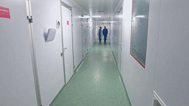 科学家们走在实验室走廊上。制药工人在实验室走廊