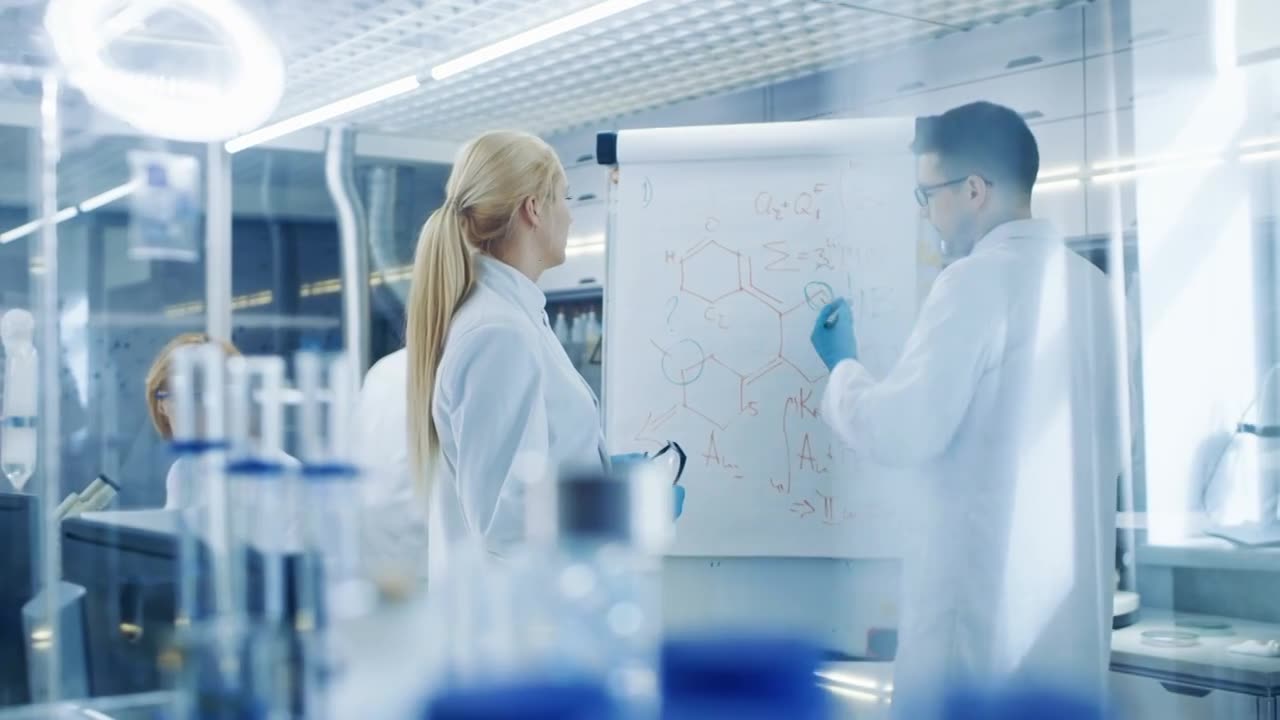 详情图-年轻的男女科学家在白板上写公式。他们在光明现代高科技实验室里解决科学问题。