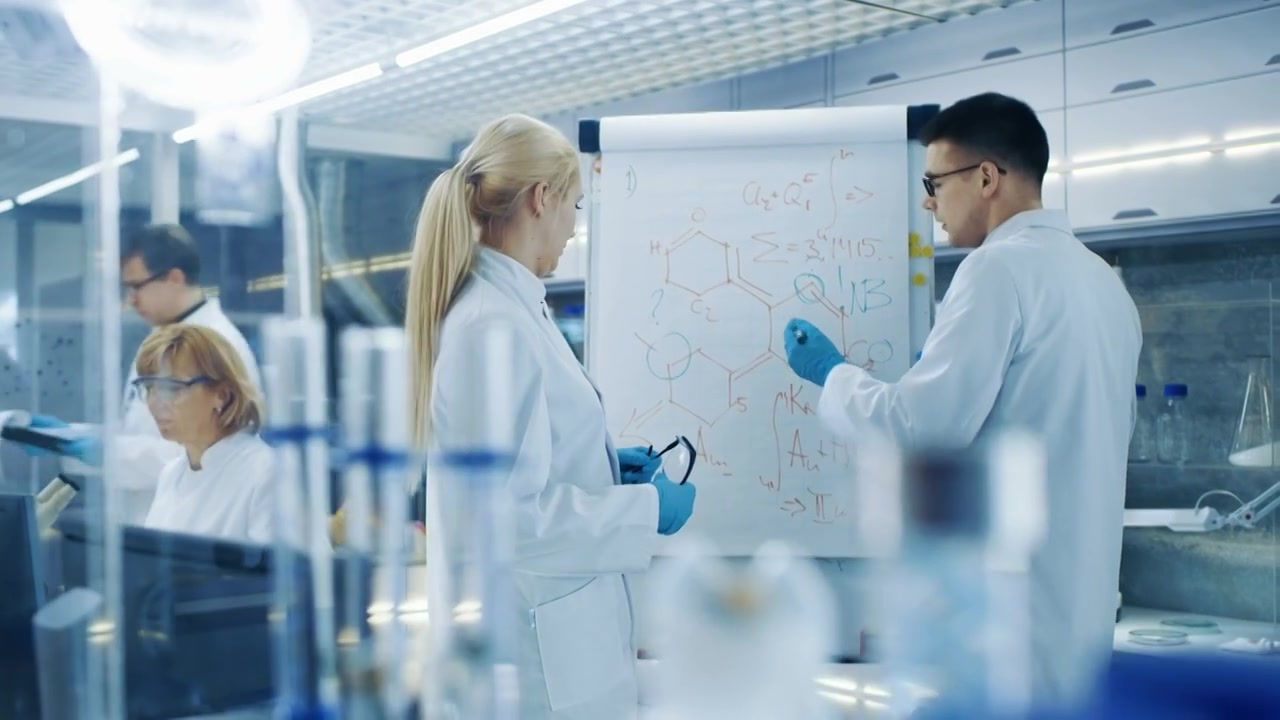 详情图-年轻的男女科学家在白板上写公式。他们在光明现代高科技实验室里解决科学问题。