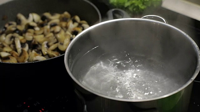 锅内沸水，以炸蘑菇为背景。慢动作