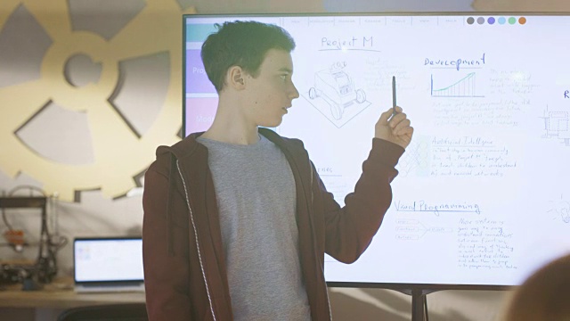 一名男孩在互动白板上为即将到来的学校科学课做演示。