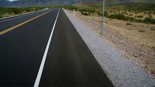 沙漠空旷的公路行走从脚向上看标志