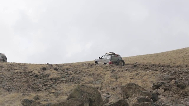 远征越野车在崎岖的山路上缓慢行驶。