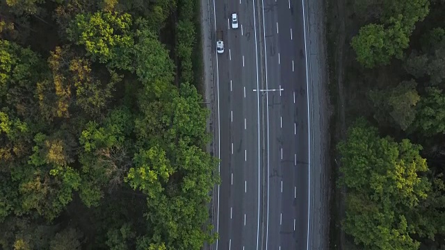 汽车沿着绿树环绕的道路行驶。鸟瞰图