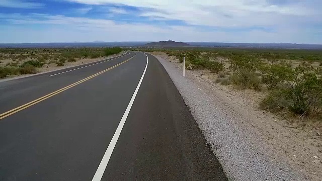 沙漠空旷的公路行走从脚向上看标志