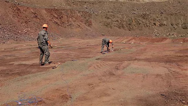 铁矿开采，在采石场开采铁矿时准备爆破，露天爆破作业，铺炸药