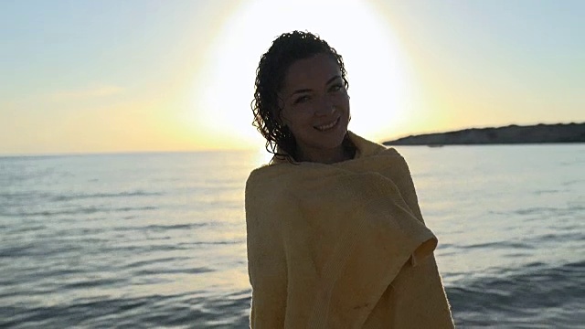 湿女孩在海里游泳后把毛巾放在肩膀上