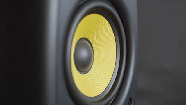 特写在移动大黄色扩散器。“。扬声器低音炮在嘈杂的音乐中振动。慢动作