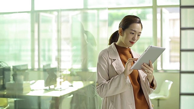 亚洲女商人在办公室使用数字平板电脑
