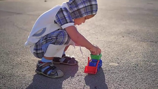 孩子在操场上玩玩具车和粉笔。户外游戏