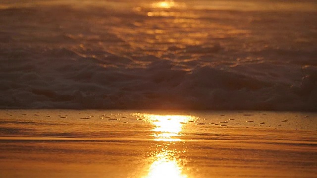 详情图-美丽的金色海浪在日落。橙色的日出倒映在海水上。在刮风的夜晚，带着波浪的潮水溅起水花。自然背景特写慢动作