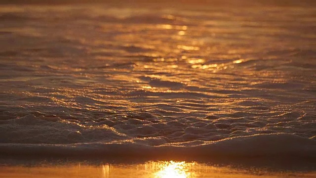 详情图-美丽的金色海浪在日落。橙色的日出倒映在海水上。在刮风的夜晚，带着波浪的潮水溅起水花。自然背景特写慢动作