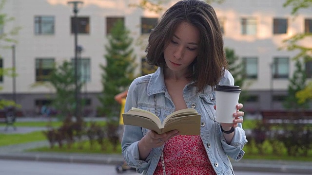 女孩在公园里看书，在夏天的夕阳下