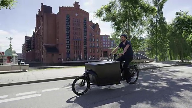 帅气的货运自行车快递正在大街上骑车