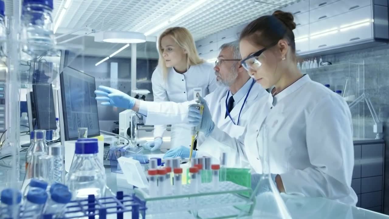 详情图-研究科学家团队使用个人计算机，分析试验试验新一代药物数据。他们在一个现代化的实验室/医疗中心工作。
