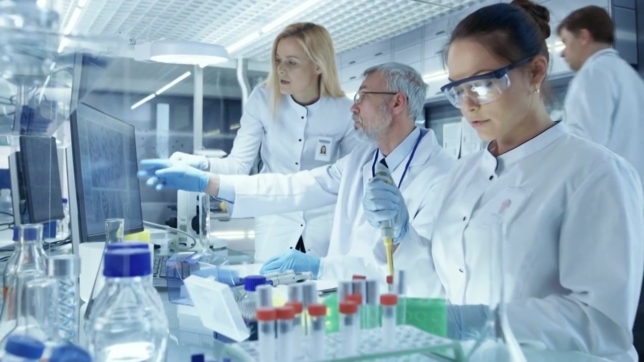 详情图-研究科学家团队使用个人计算机，分析试验试验新一代药物数据。他们在一个现代化的实验室/医疗中心工作。