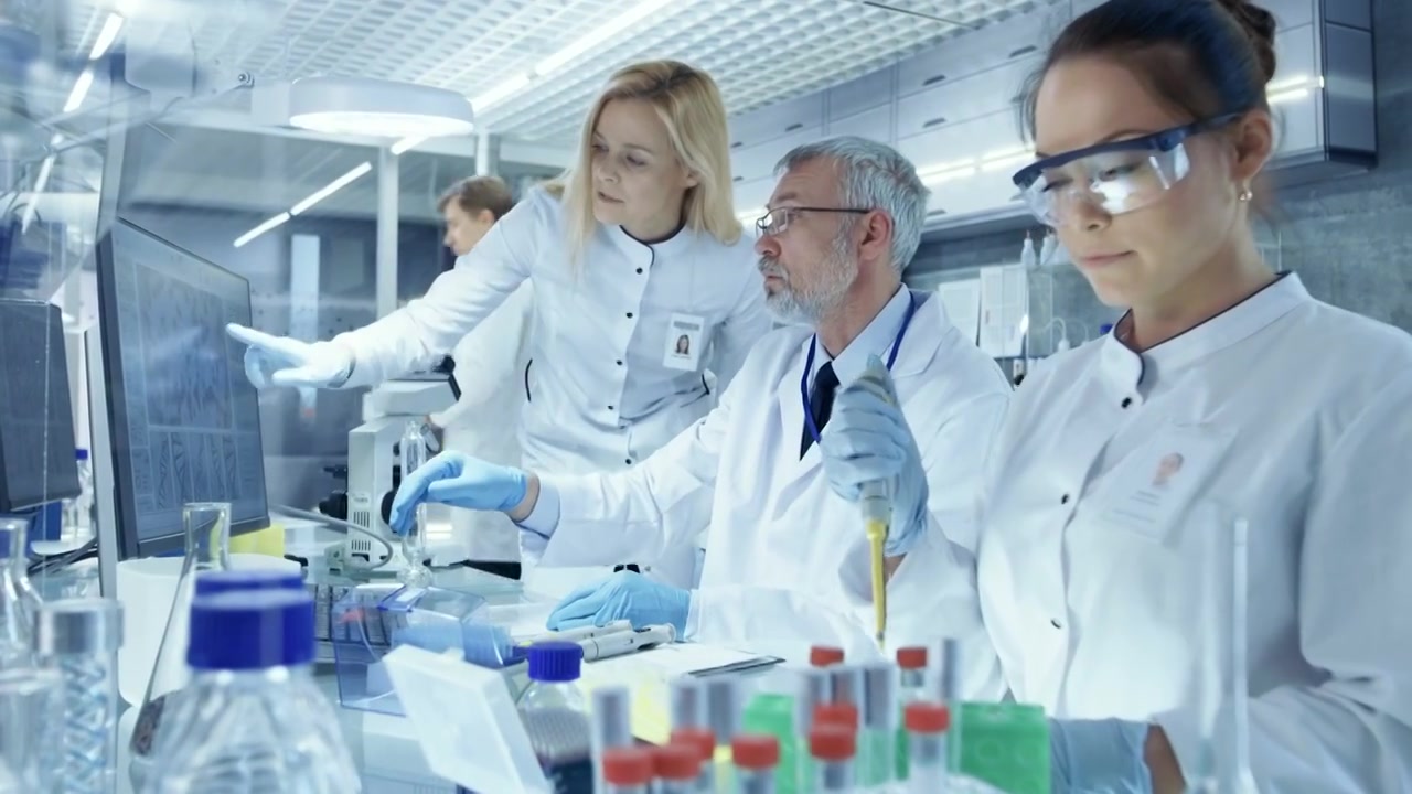 详情图-研究科学家团队使用个人计算机，分析试验试验新一代药物数据。他们在一个现代化的实验室/医疗中心工作。