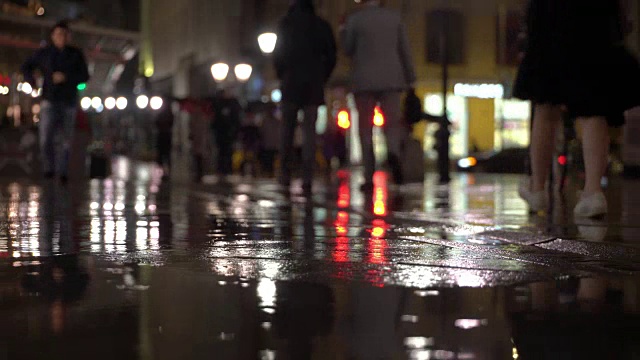 详情图-雨夜，在路灯的照耀下，雨点落在五颜六色的沥青上。不认识的人在雨伞下走，过有红绿灯的马路。美丽的彩色的散景。天气、交通、城市街道、现代城市生活方式的概念