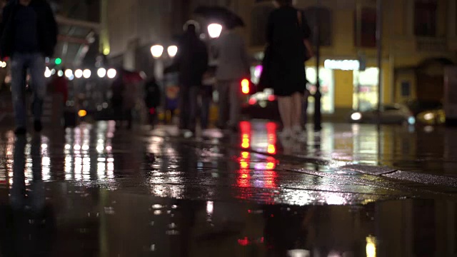 详情图-雨夜，在路灯的照耀下，雨点落在五颜六色的沥青上。不认识的人在雨伞下走，过有红绿灯的马路。美丽的彩色的散景。天气、交通、城市街道、现代城市生活方式的概念