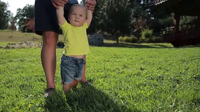 可爱的婴儿在爸爸的帮助下迈出了第一步