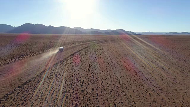 鸟瞰图的旅游车辆行驶在沙砾道路在纳米比亚的沙漠