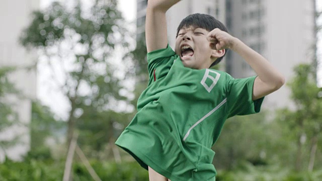 亚洲青少年足球运动员跳跃和欢呼后，射击和得分的慢动作
