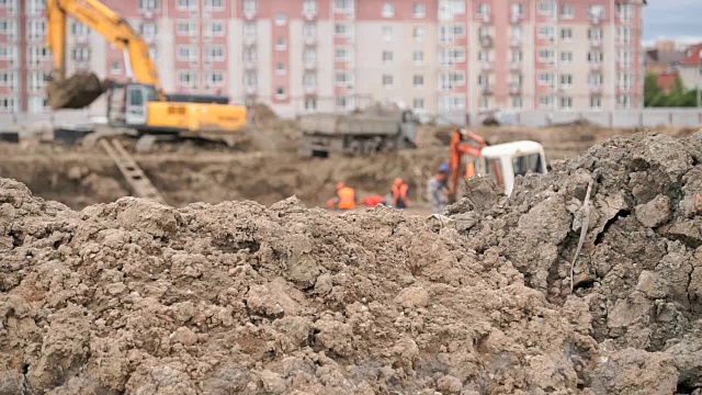 建筑工人们在一个大的粘土坑里施工
