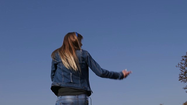 詳情圖-慢動作的漂亮的年輕女孩跳上蹦床和聽音樂