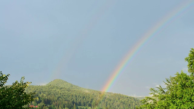 彩虹越过高山。间隔拍摄。