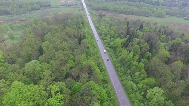 穿过森林和村庄通往山区的道路。鸟瞰图