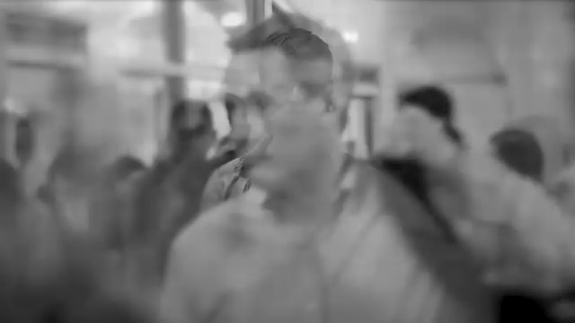 一个白人站在大街上，周围都是快速移动的人。上班族的生活背景。黑色和白色