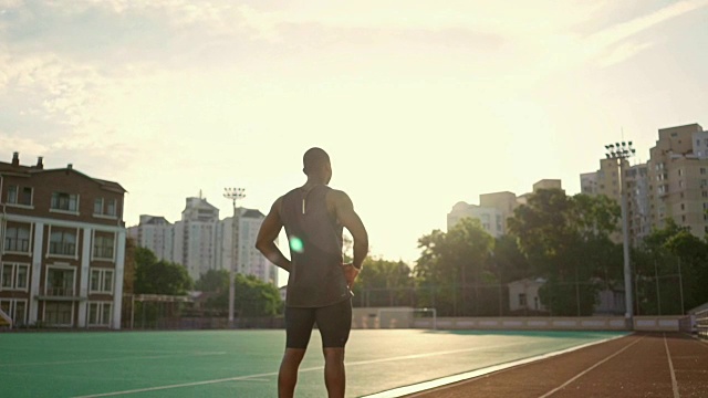 非洲年轻男运动员站在跑步场上